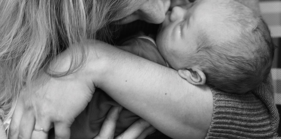 Baby innig in de armen van moeder, neus aan neusje.