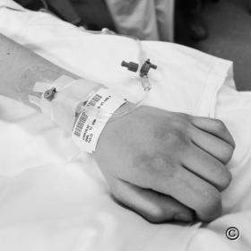 Hand van 17 jarige jongen waarin infuus zit.
